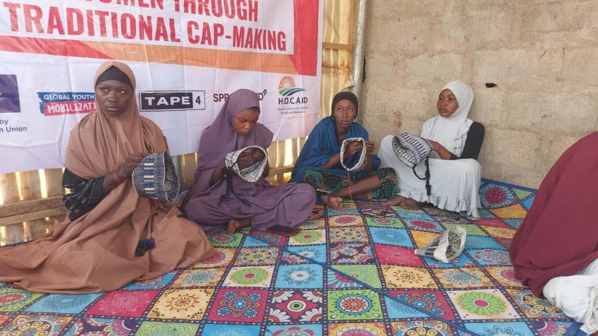 Young women displaying traditional caps they made during HOCAID's livelihoods skills training in Borno State